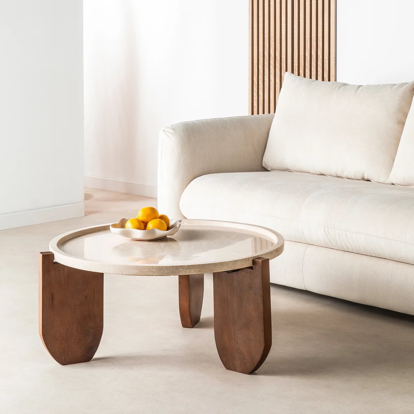 Table basse ronde Nador en marbre et bois massif dans un salon contemporain