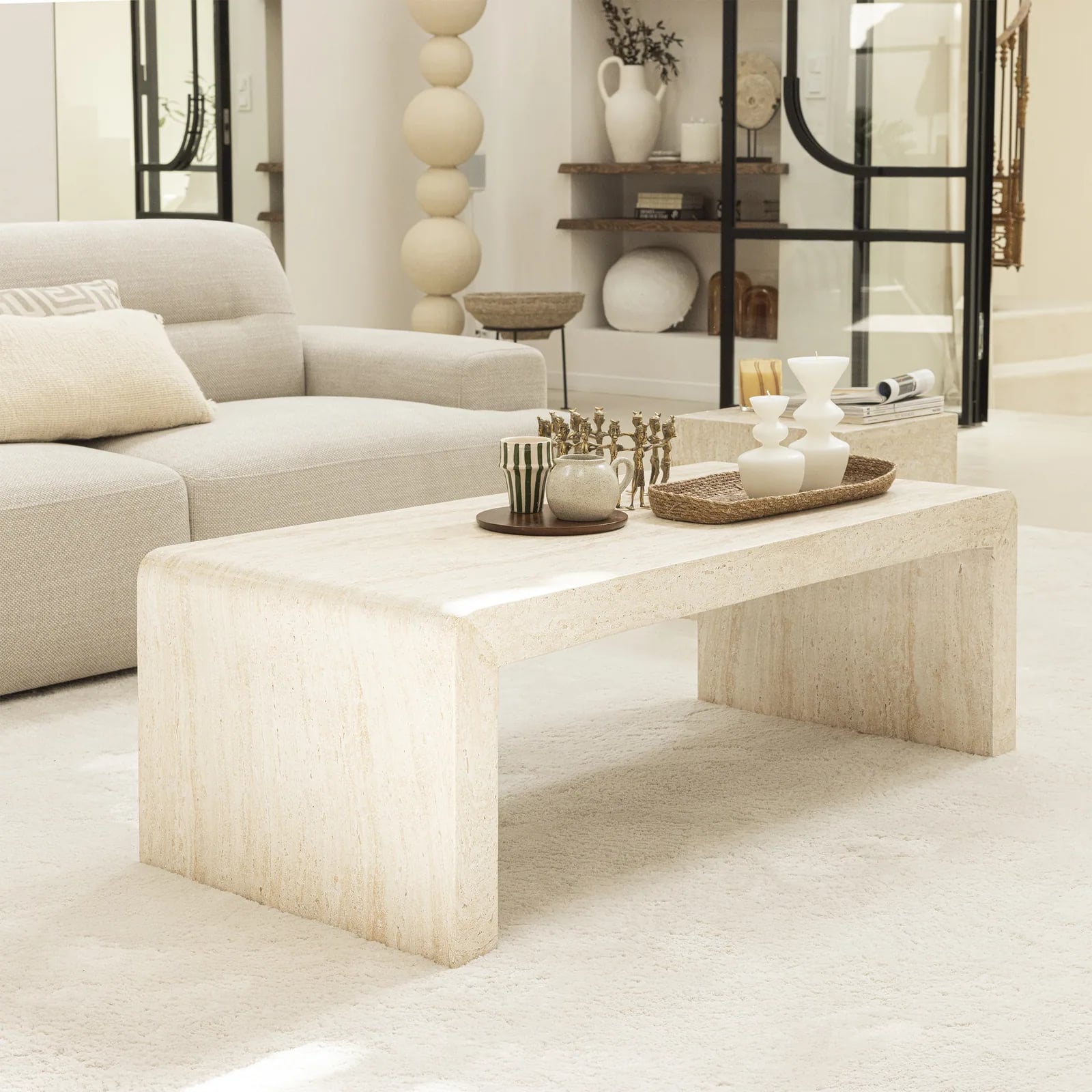 Table basse au décor travertin dans un salon contemporain aux tons ivoire