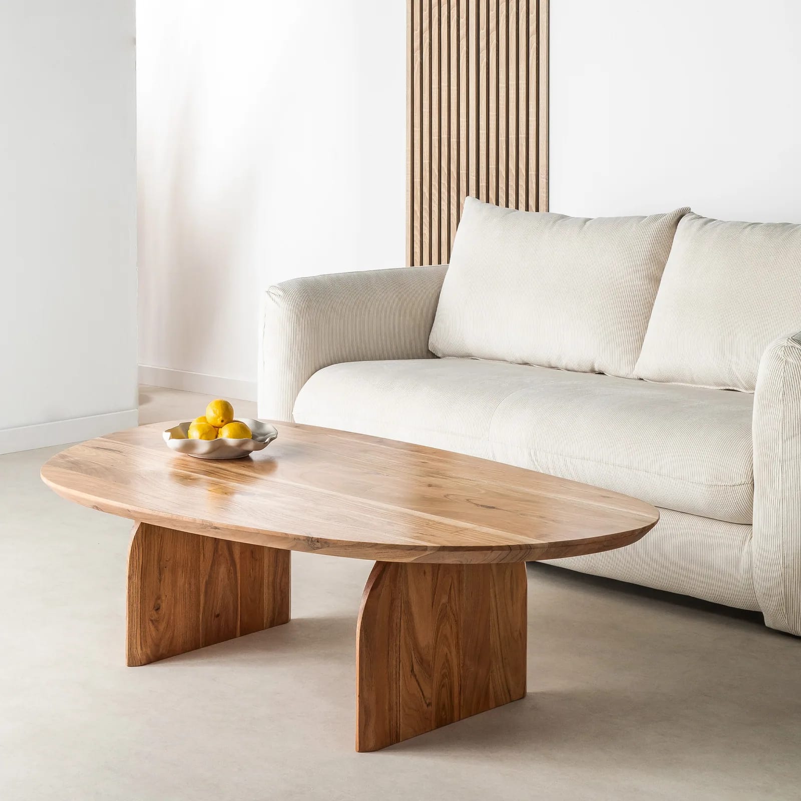 Table basse organique Malang en acacia massif dans un salon lumineux